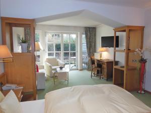 a hotel room with a bed and a desk and a room at Hotel Hubertushof in Ibbenbüren