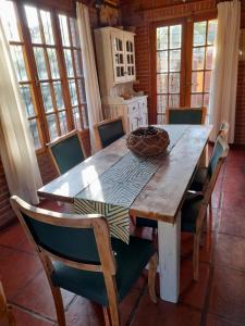 eine Küche mit einem Holztisch und Stühlen drumherum in der Unterkunft La Maga, Casa para Familias in Pinamar