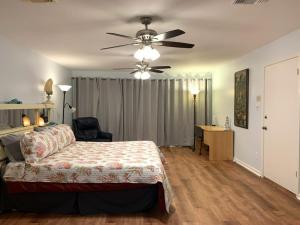 een slaapkamer met een bed en een plafondventilator bij Paradise lagoon*bayhouse fishing*beach*Dogfriendly in Galveston