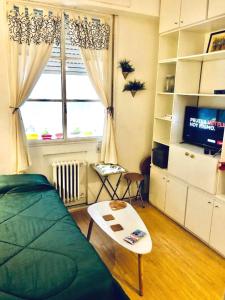 1 dormitorio con 1 cama, TV y mesa en Monoambiente en el Centro y Recoleta!! en Buenos Aires