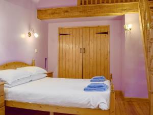 a bedroom with a bed with white sheets and a wooden door at The Barn - B6206A in Onecote