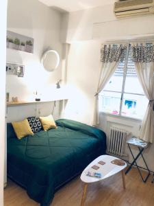 Un dormitorio con una cama verde y una ventana en Monoambiente en el Centro y Recoleta!! en Buenos Aires