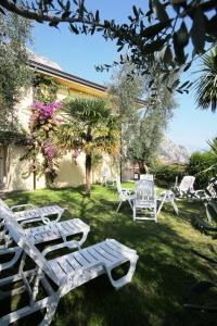 a group of white chairs sitting in a yard at Hotel Susy in Limone sul Garda