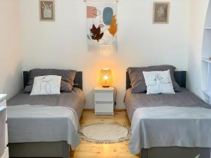 - 2 lits dans une petite chambre avec une lampe dans l'établissement Old Town Apartment Przemyśl, à Przemyśl