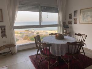 a dining room with a table and a large window at Acre sea view 11th floor apartment in ‘Akko