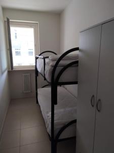 トルトレート・リドにあるResidenza il Grecaleの二段ベッド2台、窓が備わる小さな客室です。