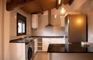 een keuken met een koelkast en een wastafel bij MonResidence La Figuereta in Manresa