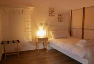 ein Schlafzimmer mit einem Bett und einer Lampe auf einem Tisch in der Unterkunft MonResidence La Figuereta in Manresa
