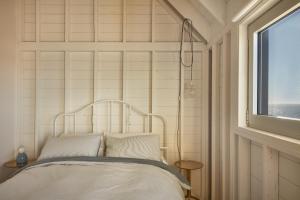 Cama en habitación con ventana en Les Rochers - Îles de la Madeleine, en Havre-Aubert