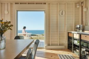 a dining room with a table and a view of the ocean at Les Rochers - Îles de la Madeleine in Havre-Aubert