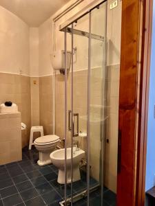 a bathroom with two toilets and a glass shower at Foresteria Santa Maria di Betlem in Foligno