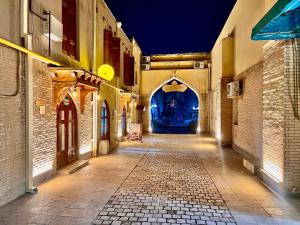 an empty alley with an archway in a building at Miniature Boutique Hotel in Bukhara