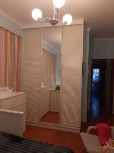 1 dormitorio con un espejo grande en una habitación en Almadense, en Almada