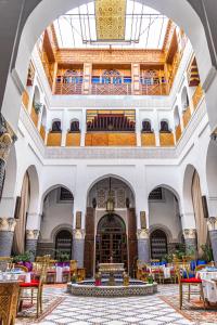 - une vue sur le hall d'un hôtel avec des tables et des chaises dans l'établissement Riad El Yacout, à Fès