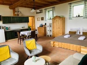 a bedroom with a bed and a kitchen with a table at Édenkert Vendégházak in Pécsvárad