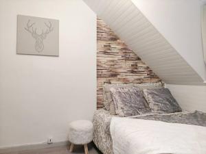 1 dormitorio con cama y pared de ladrillo en Sur les toits, studio centre-ville, WIFI Netflix, en Montbéliard