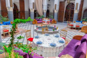 a room with a table and chairs in a building at Riad El Yacout in Fez