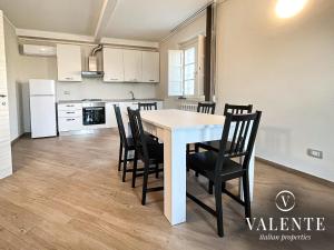 una cucina e una sala da pranzo con tavolo e sedie bianchi di Villa Valente - Apartments a Capannori