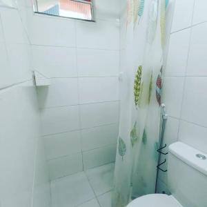 y baño con cortina de ducha y aseo. en Casa Oliveira's Paquetá, en Río de Janeiro