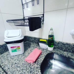 - un comptoir de cuisine avec évier et une bouteille de nettoyant dans l'établissement Casa Oliveira's Paquetá, à Rio de Janeiro