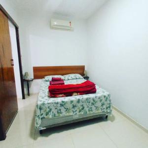um quarto com uma cama com um cobertor vermelho em Casa Oliveira's Paquetá no Rio de Janeiro