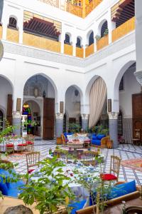 a large courtyard with tables and chairs and a pond at Riad El Yacout in Fez