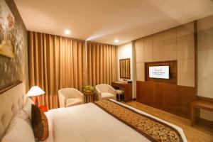 a hotel room with a bed and a flat screen tv at Muong Thanh Grand Bac Giang Hotel in Bắc Giang