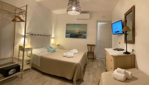 a hotel room with two beds and a television at HOTEL rurale Essenza di Mirto in La Caletta