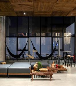 uma sala de estar com um sofá e redes de descanso em ibis Styles Maceió Pajuçara em Maceió