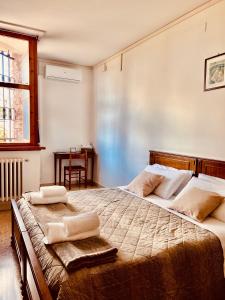 a bedroom with a large bed with two towels on it at Foresteria Santa Maria di Betlem in Foligno