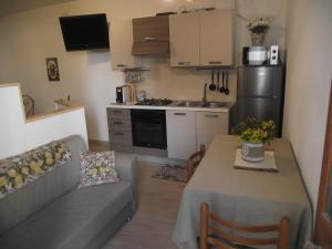 - une petite cuisine avec un canapé et une table dans une chambre dans l'établissement CASETTA_JOLANDA, à Trapani