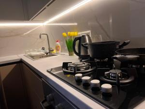 una cucina con piano cottura e lavandino con fiori gialli di Hi-tech aparts a Chişinău