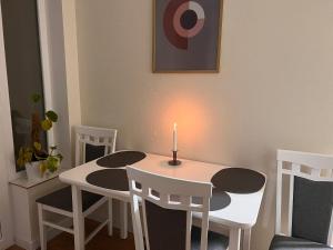 a room with a table and chairs with a candle on it at Hi-tech aparts in Chişinău