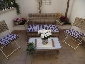 um alpendre com duas cadeiras e um banco com um vaso de flores em CASETTA_JOLANDA em Trapani
