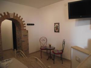 - un salon avec une table, des chaises et une télévision dans l'établissement CASETTA_JOLANDA, à Trapani