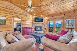 a living room with couches and a fireplace in a log cabin at Paradise Found, Hot Tub, Mtn Views, Game Room, 560 FREE tickets each paid day! in Sevierville