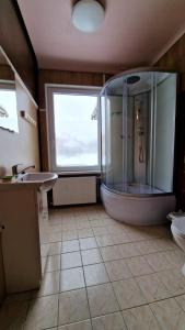 a bathroom with a large tub and a sink at Pie Parka in Alūksne