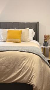 un letto con un cuscino giallo sopra di Departamento nuevo en el corazón de la Condesa a Città del Messico