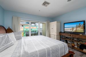 una camera da letto con un letto e una TV a schermo piatto di Harbour House at the Inn 210 a Fort Myers Beach
