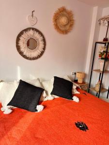 ベレス・マラガにあるB&B Casa Louisa, Torre del Mar- Vallenizaのベッドルーム1室(オレンジ色の毛布と鏡付きのベッド1台付)
