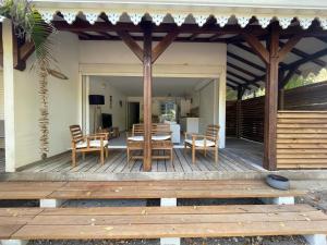 una terrazza in legno con tavolo e sedie. di Kay Agapi - Apt T3 sur la plage - Diamant a Le Diamant