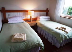 two beds in a room with a lamp and a bag at Waterville Holiday Homes No 10 in Waterville