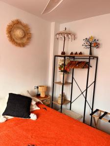 ベレス・マラガにあるB&B Casa Louisa, Torre del Mar- Vallenizaのベッドルーム1室(オレンジ色の毛布と棚付きのベッド1台付)