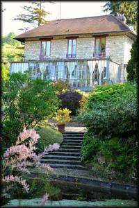 a stone house with stairs in front of a house at La Pluie de Roses in Giverny
