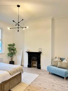ein Schlafzimmer mit einem Bett, einem Stuhl und einem Klavier in der Unterkunft Fayhomes West Midlands Luxury Late 1800 Property in Walsall