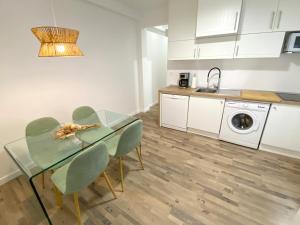kuchnia i jadalnia ze szklanym stołem i krzesłami w obiekcie Apartamento La Merced w Maladze