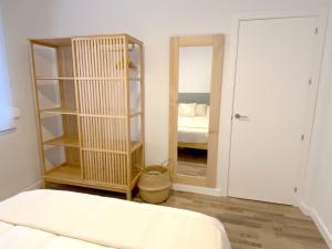 sypialnia z łóżkiem i pokój z lustrem w obiekcie Apartamento La Merced w Maladze