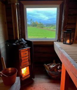 a room with a large window and a stove at Litet hus på landet 