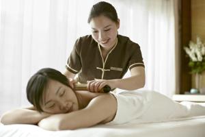 a woman and a man laying on a bed at Kerry Hotel Pudong, Shanghai in Shanghai