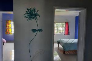 a painting of a flower on a wall in a bedroom at Artist Villa in a Beautiful Yard in Chilanga